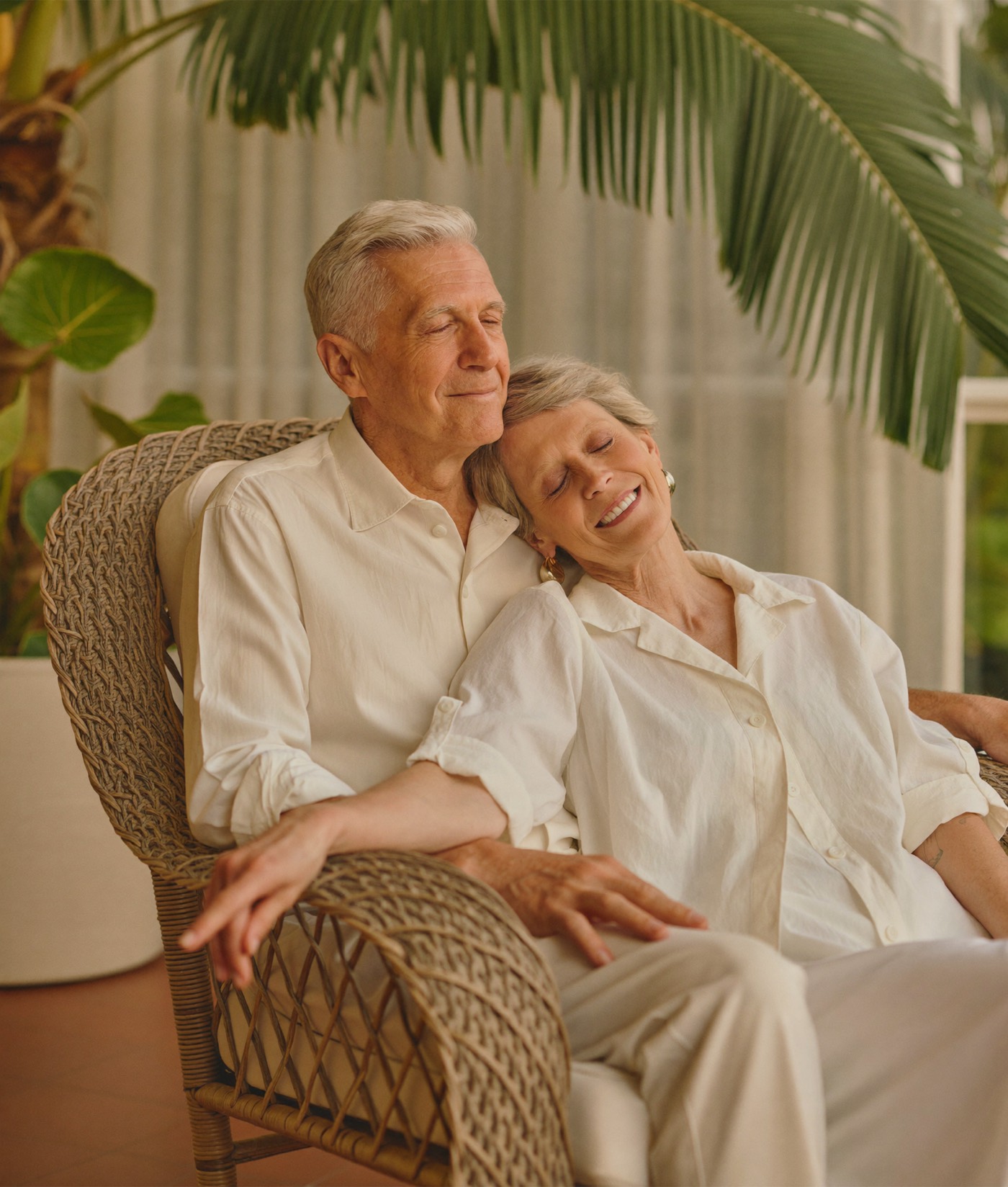 A content senior couple relaxing together on their sunlit Florida lanai