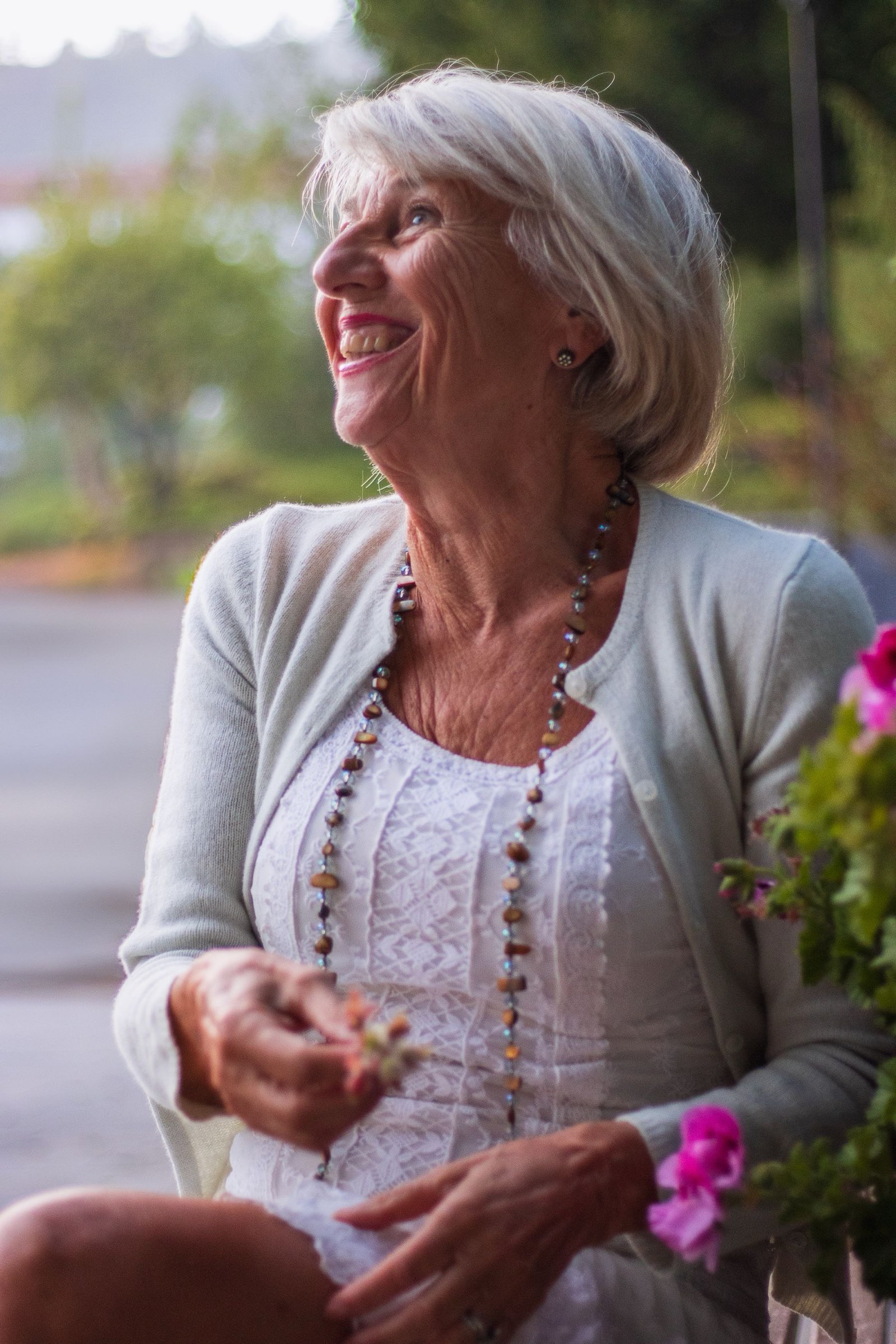 A senior woman laughing joyfully in golden garden light